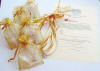 bridesmaid's charm bracelets packed in gold organza pouches to match the gold satin ribbons on the cake charms for the bridesmaid's luncheon