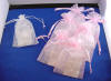 wedding jewelry order packed in matching white organzq pouch for bride's jewelry set and pink pouches for bridesmaids' jewelry sets