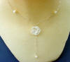 this sterling silver necklace has a white porcelain rose in the center with round freshwater pearl accents