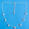 sterling silver station necklace with pink pearls dangling from chain