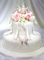 bridesmaid charm cake with cake charms on ribbons under the sugar flowers on top of the cake