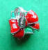 There is a 3-d red enamel bow on top of this green enamel 3-d sterling silver Christmas gift package charm
