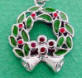 sterling silver christmas wreath charm with green and red enamel, red glass accents just above bells