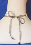 black organza and pearl necklace tied in a bow on the back of the neck