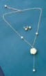 lariat-style necklace with a white porcelain rose in the front with pearl earrings